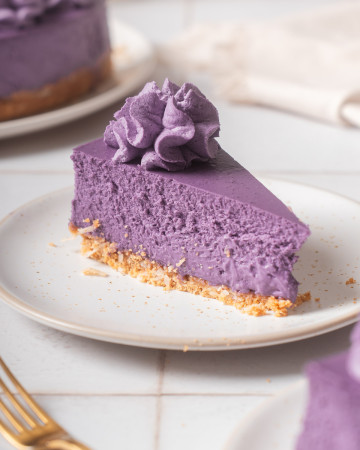 A slice of ube cheesecake on a plate.