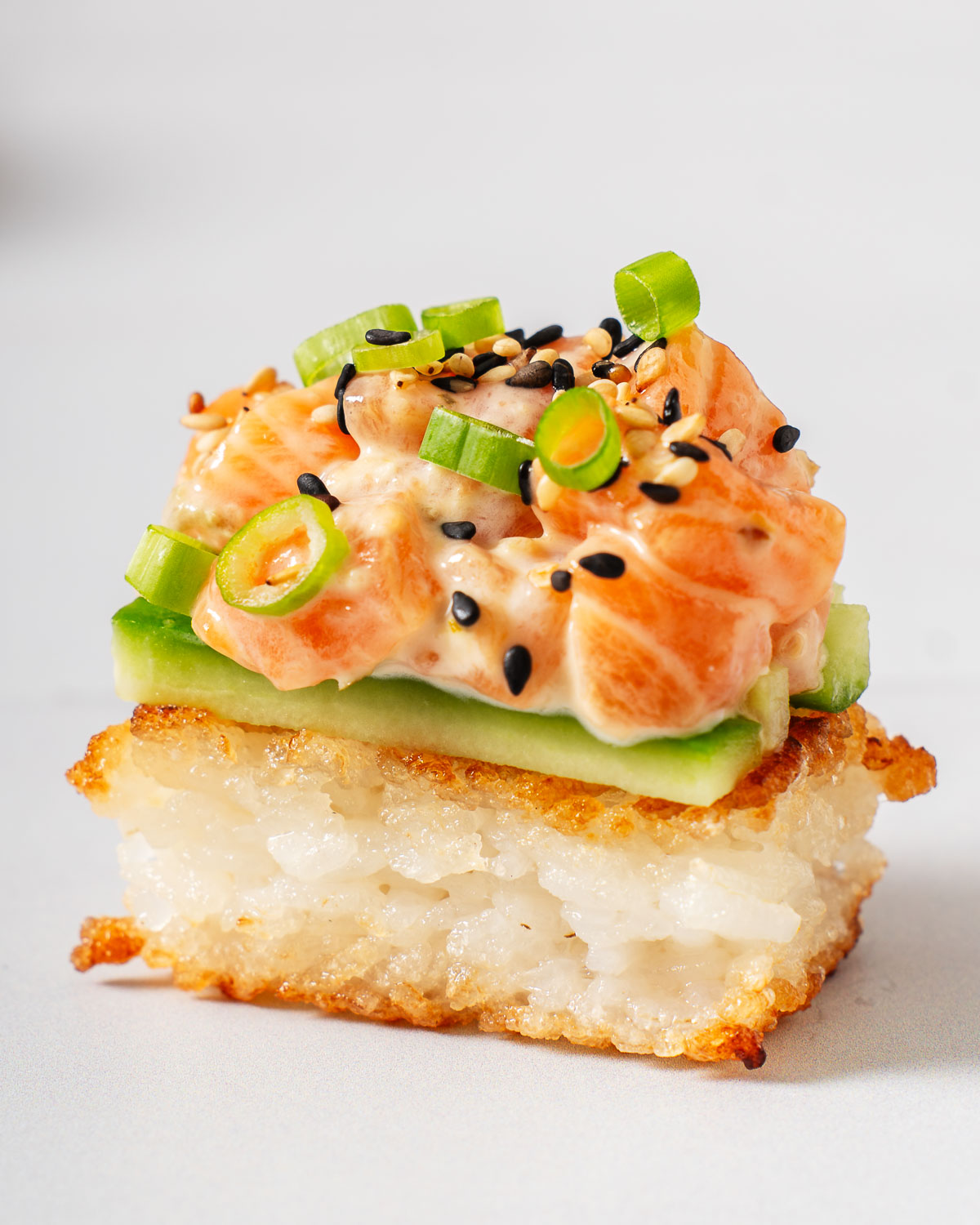 Up close with a crispy rice salmon on a marble platter.