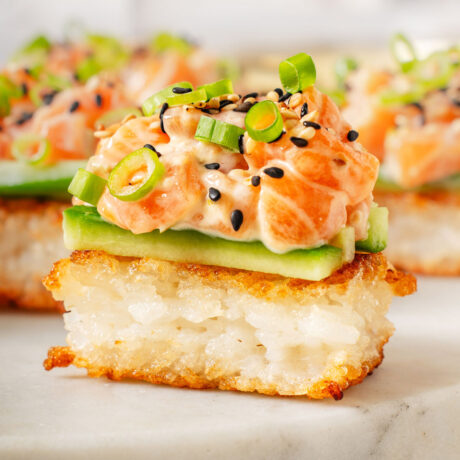 Up close with a crispy rice salmon on a marble platter.