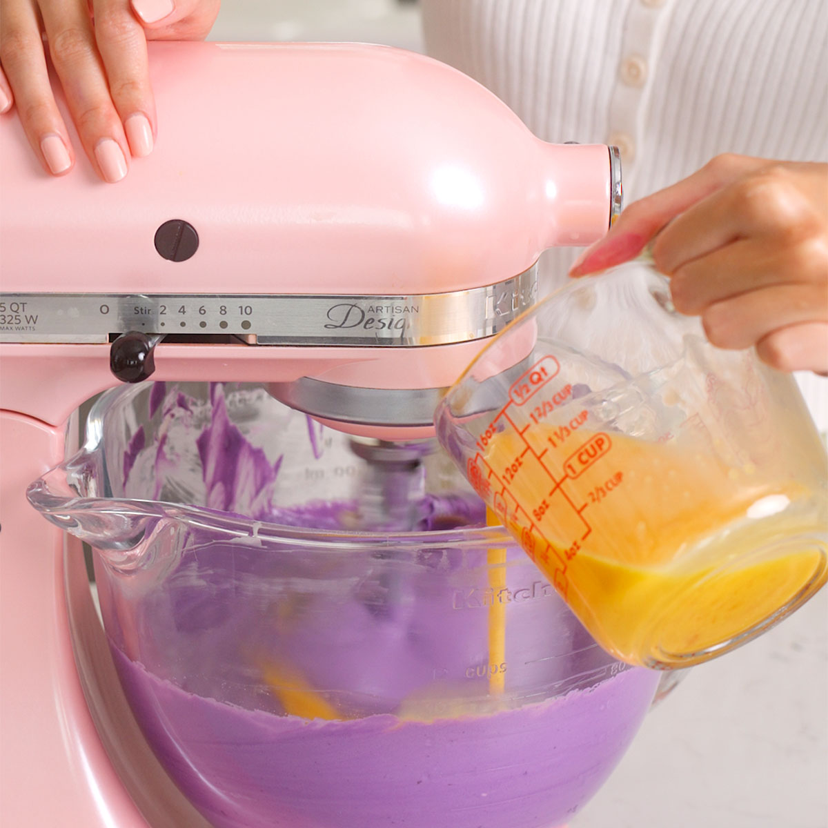 Pouring the mixed eggs into the ube cheesecake batter.