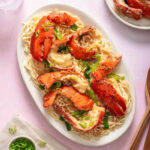 Looking down at a plate of lobster noodles on a serving platter.