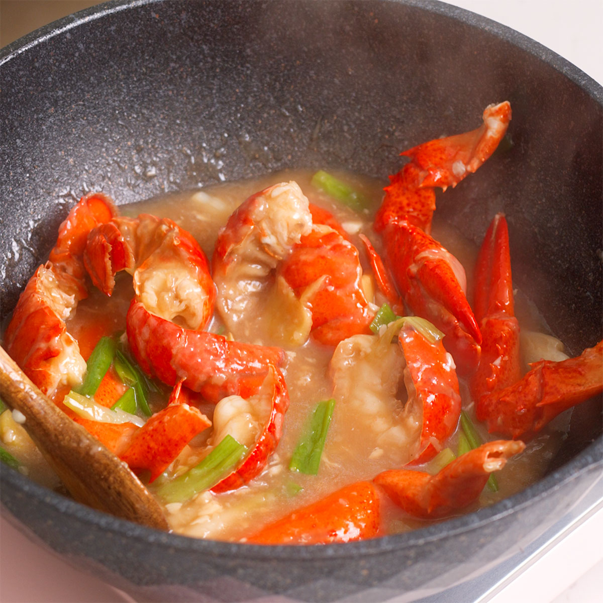Fried lobster in a sauce after completing cooking for lobster noodles.