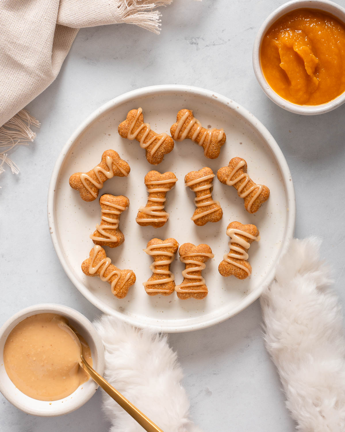 Looking down at a plate of homemade pumpkin peanut butter dog treats.