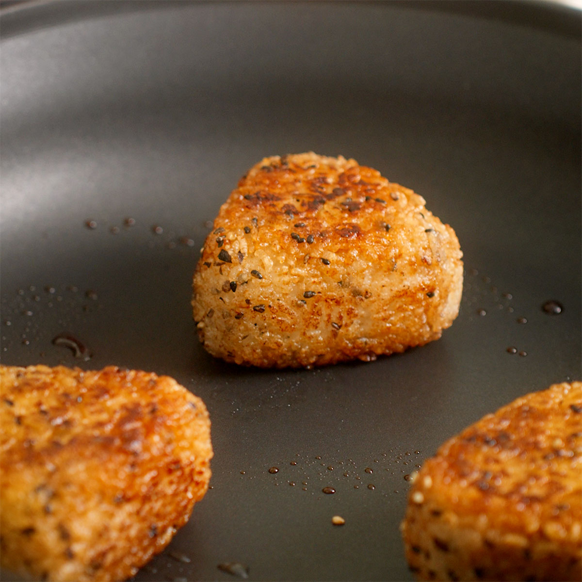 Fully grilled yaki onigiri in a skillet.