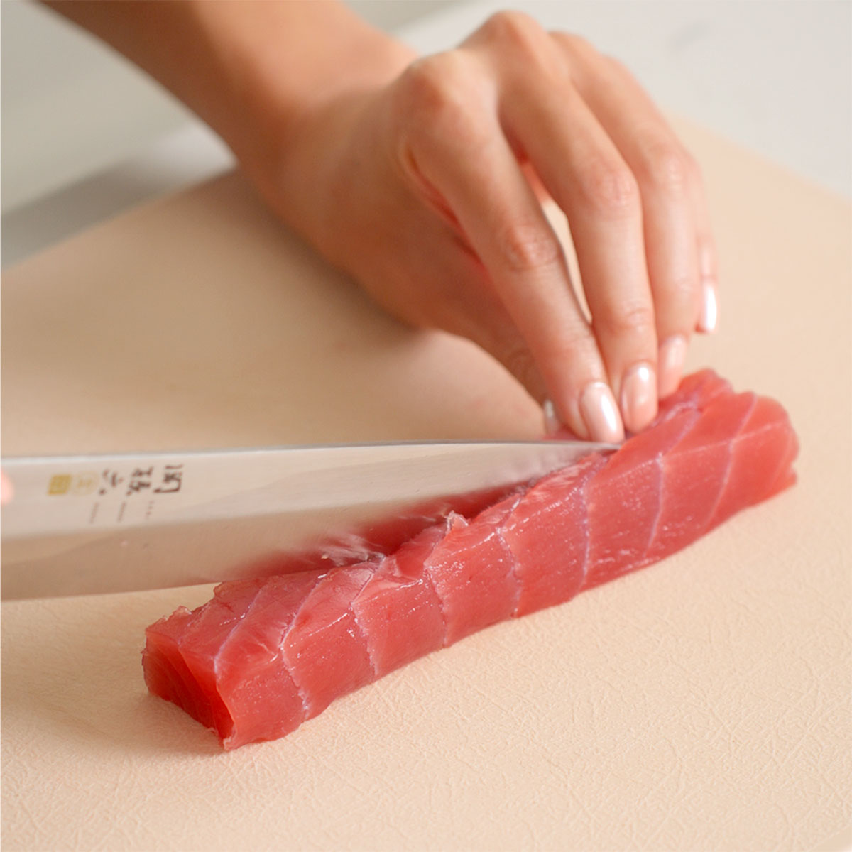 Slicing sushi grade tuna into strips for making tekka maki.
