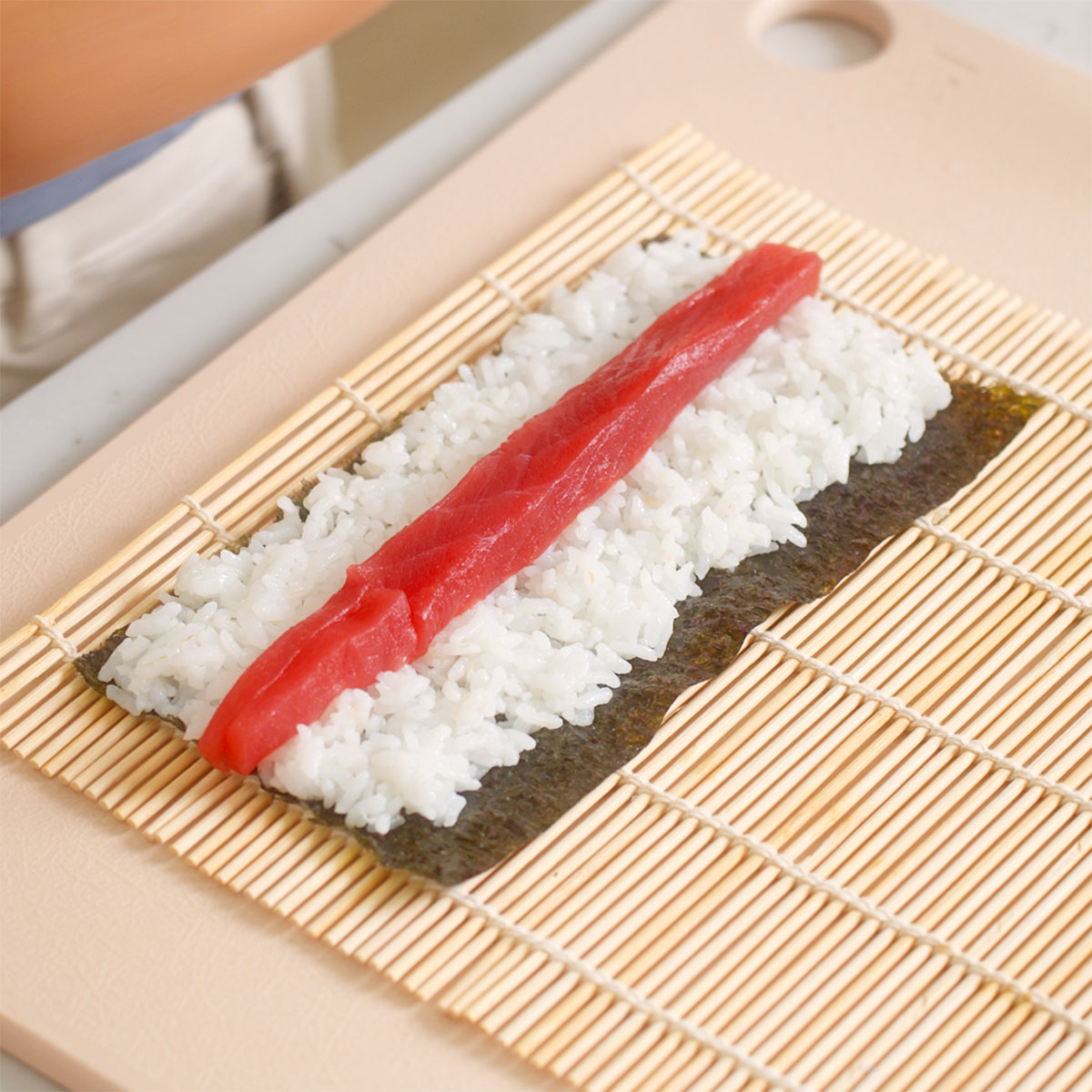 An assembled tuna roll ready to be rolled up.