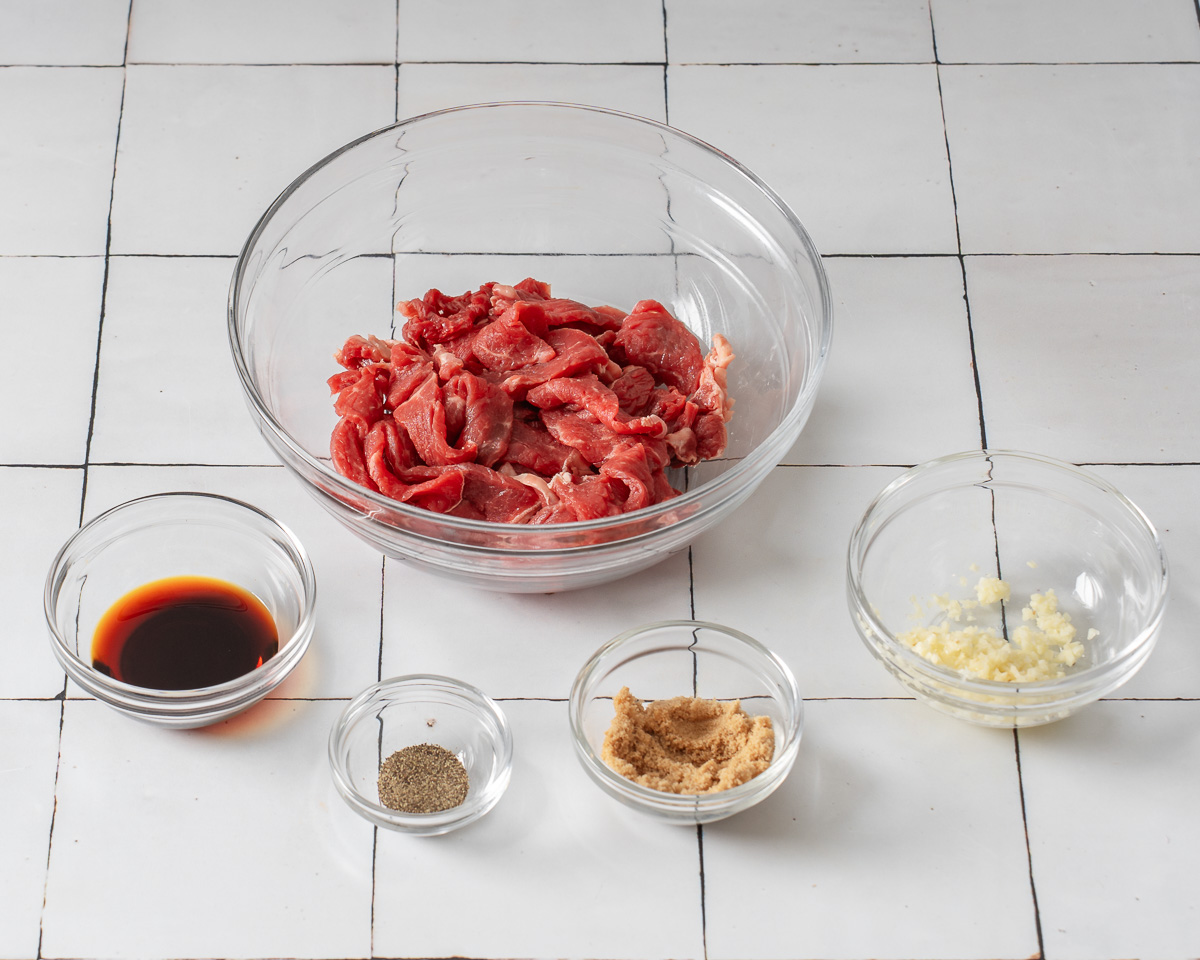 Sliced beef and seasonings organized in misen plas.