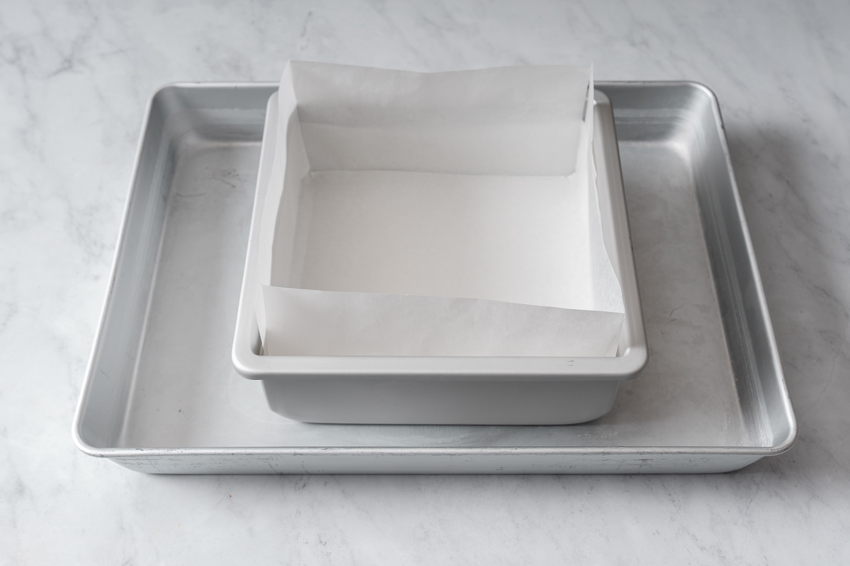 A prepared lined baking pan and water bath pan.