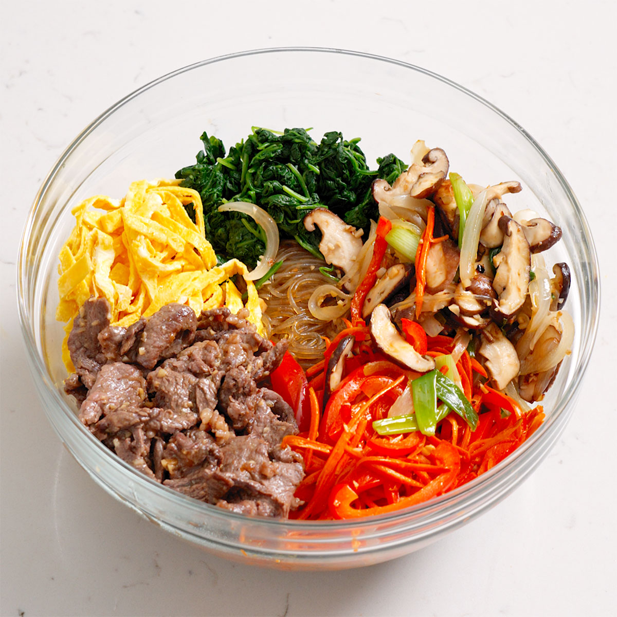 All the ingredients for japchae organized in a large mixing bowl before combining.