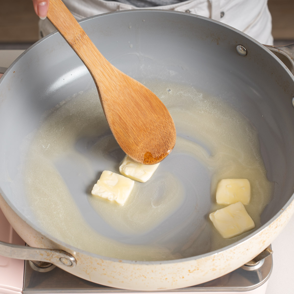 Melting butter in a large skillet.