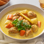 A bowl of Vietnamese chicken curry garnished with fresh cilantro.