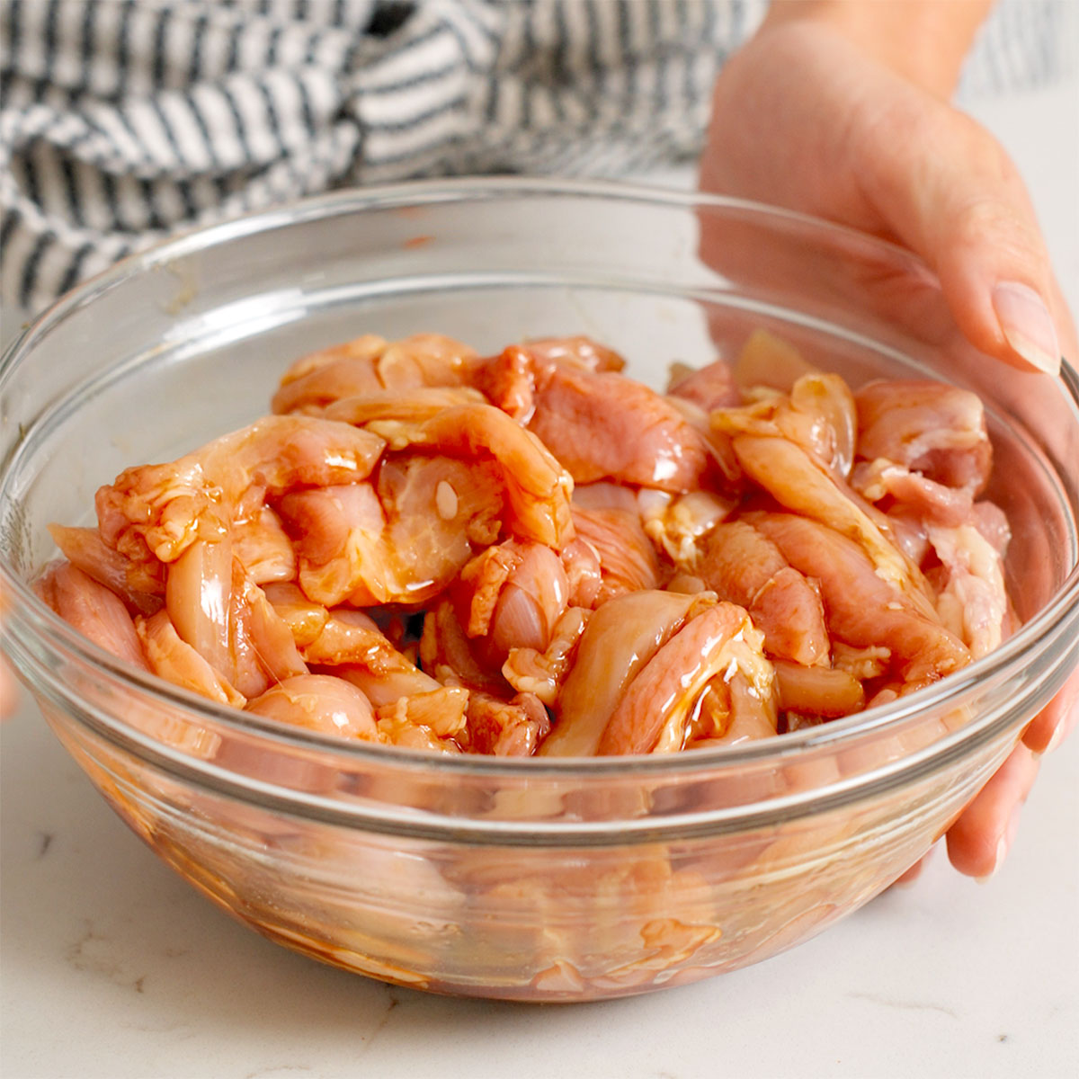 Chicken marinading in a bowl for thai pad kee mao.