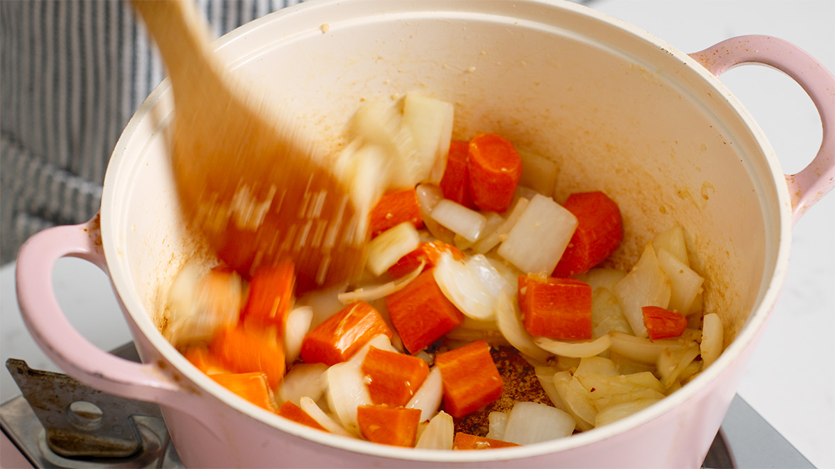 Cooking carrots in a sauce pot to soften them.