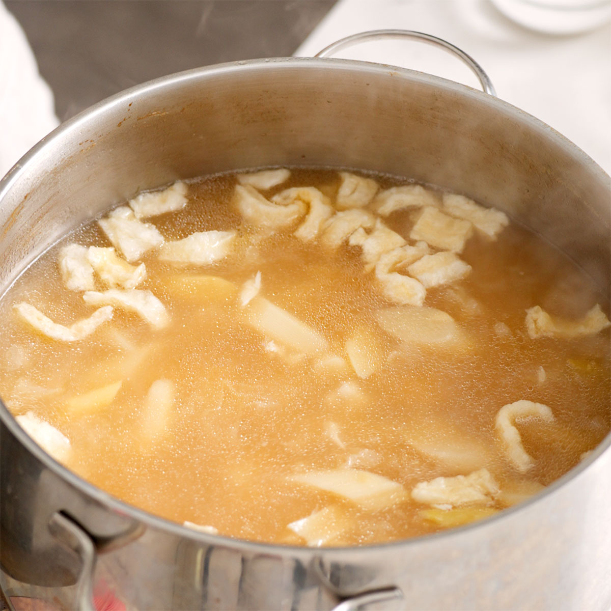 Crab, asparagus, and fungi added to a pot of pork broth.