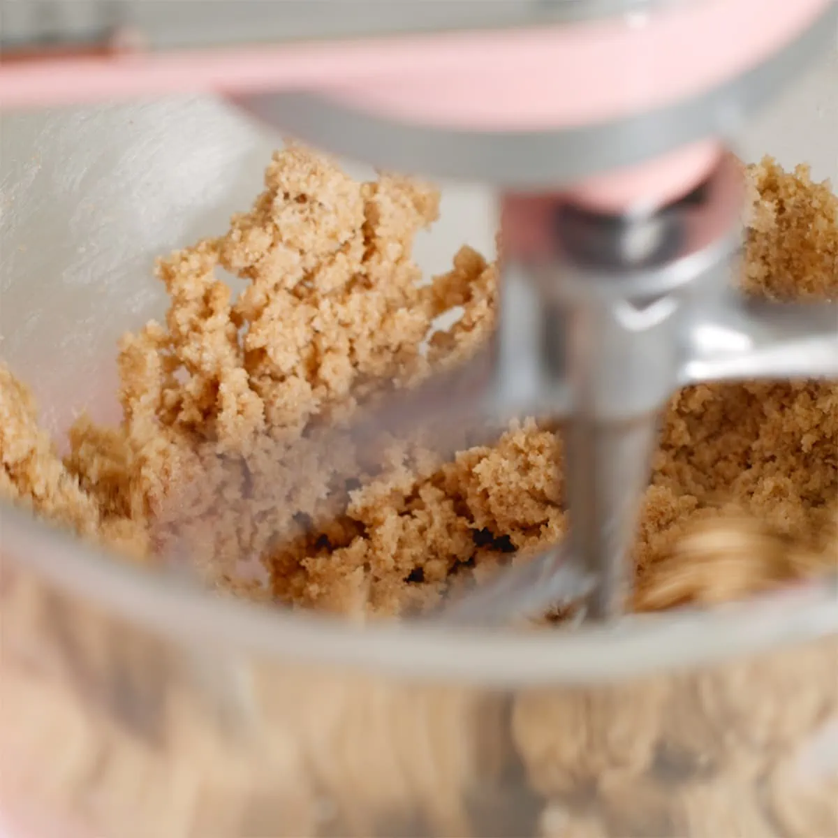 Butter and sugars being whipped inside a stand mixer.
