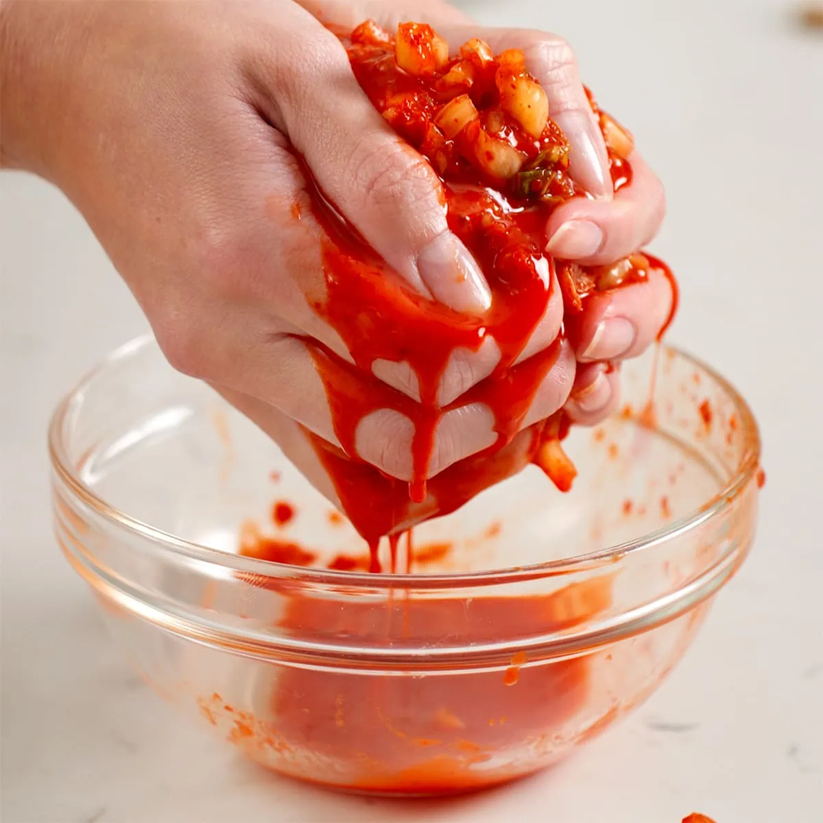 Someone squeezing the water out of chopped kimchi.