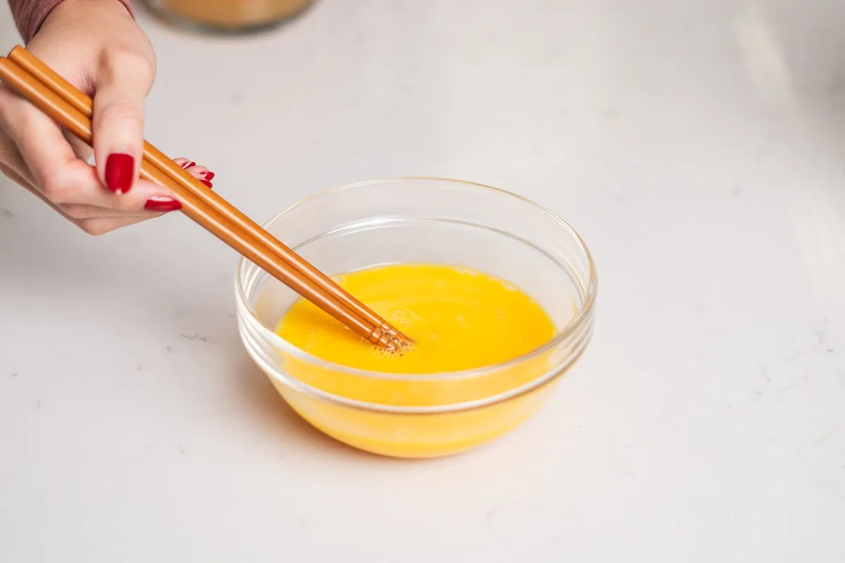 Eggs whisked together in a small glass bowl.