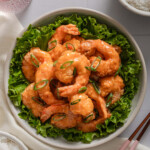 A top down view of bang bang shrimp topped with sliced green onions.