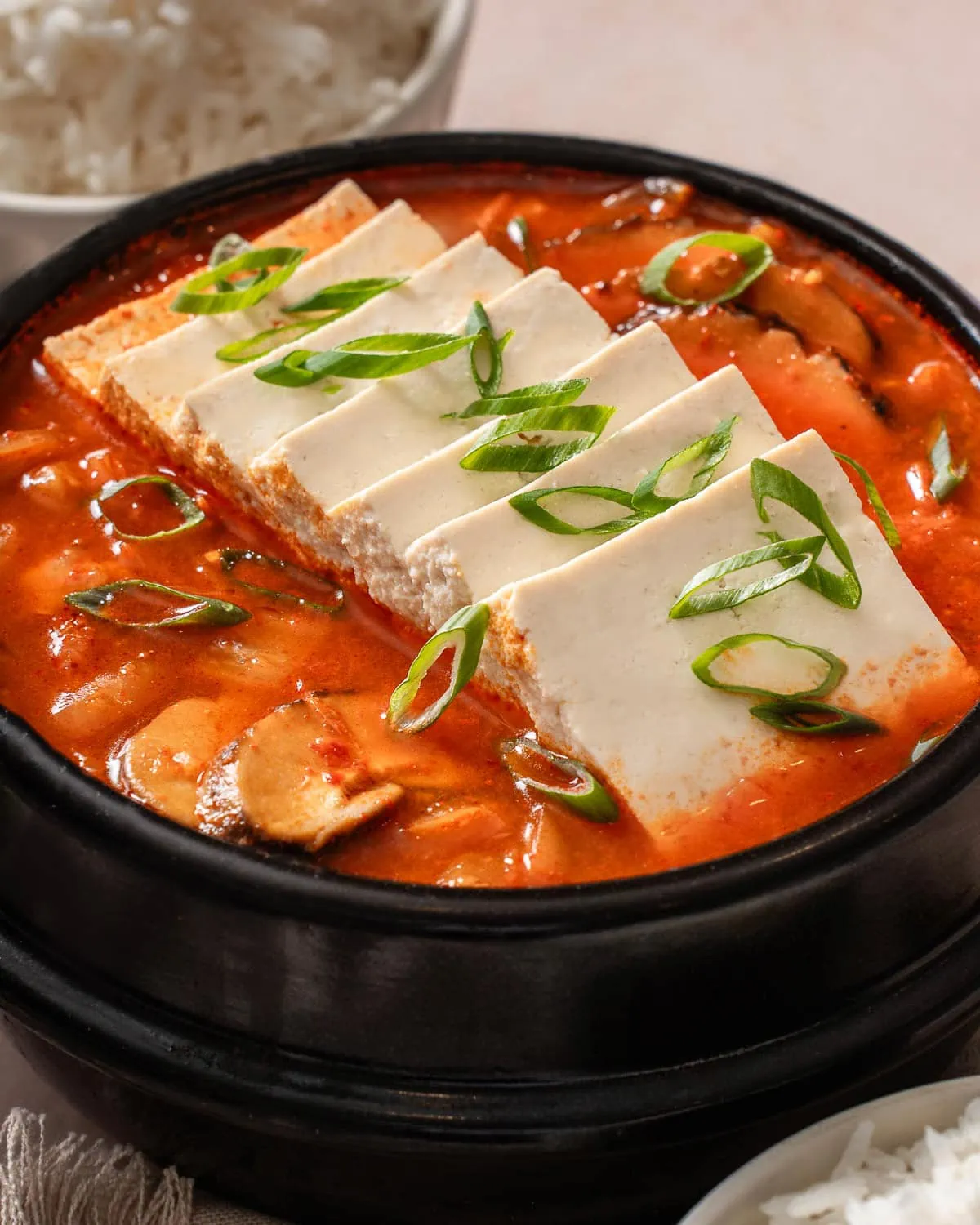 An up close shot of a pot of kimchi jjigae stew.