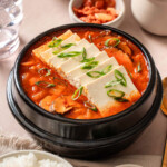 A small stone pot of kimchi jjigae stew.