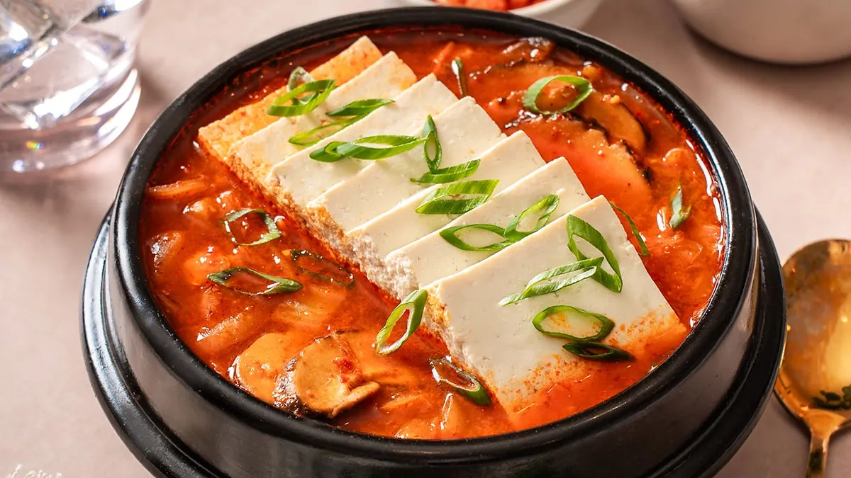 A small stone pot of kimchi jjigae stew.