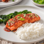 Gochujang salmon on a plate with rice and broccolini.