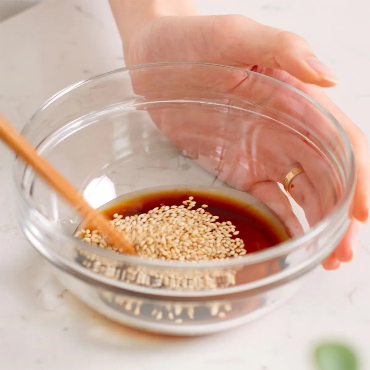 Mixing sunomono salad dressing in a glass bowl.