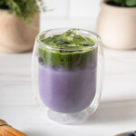 A double walled glass with a iced blueberry matcha.