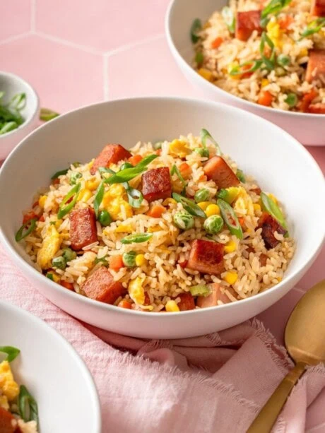 A few bowls of spam fried rice on a bright tiled surface.