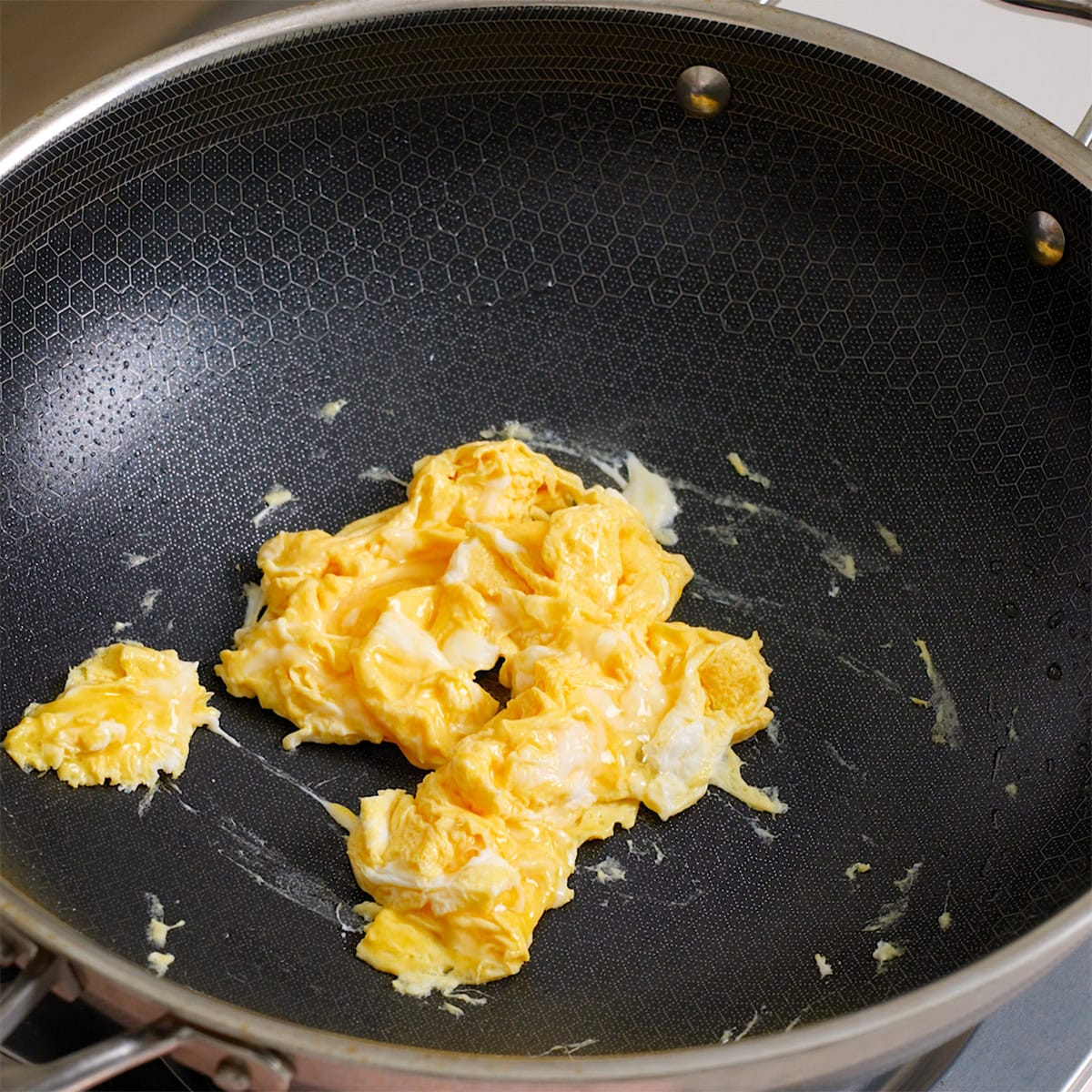 Eggs scrambled in a large wok.