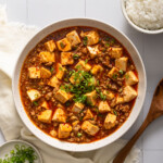 Looking down at a large serving bowl of mapo tofu.
