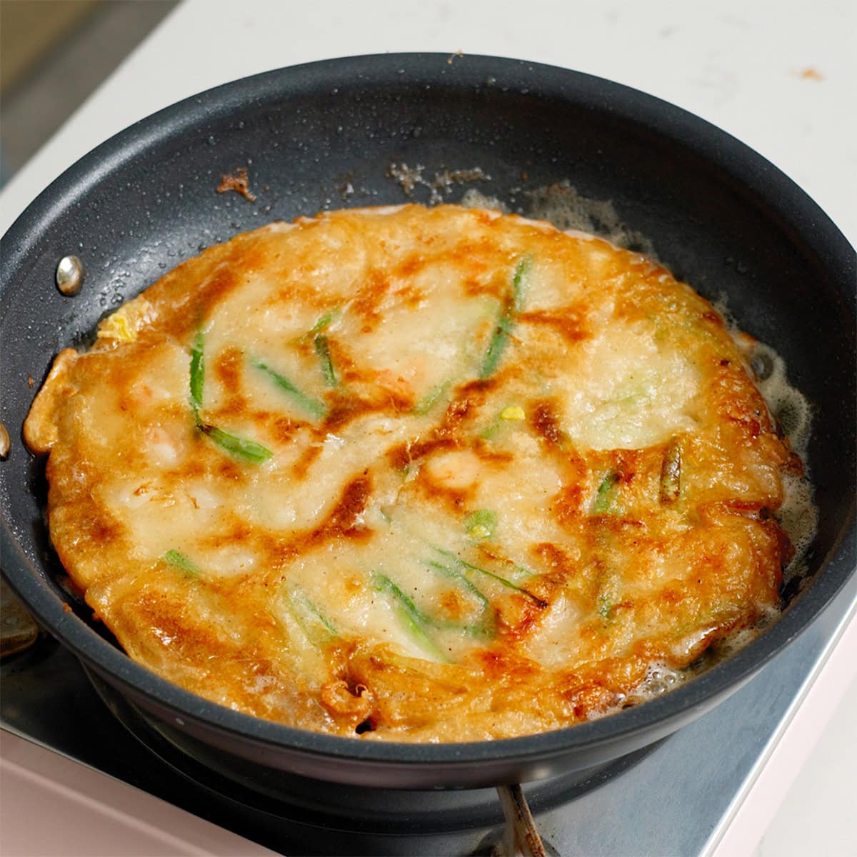 A cooked Korean seafood pancake in a pan.