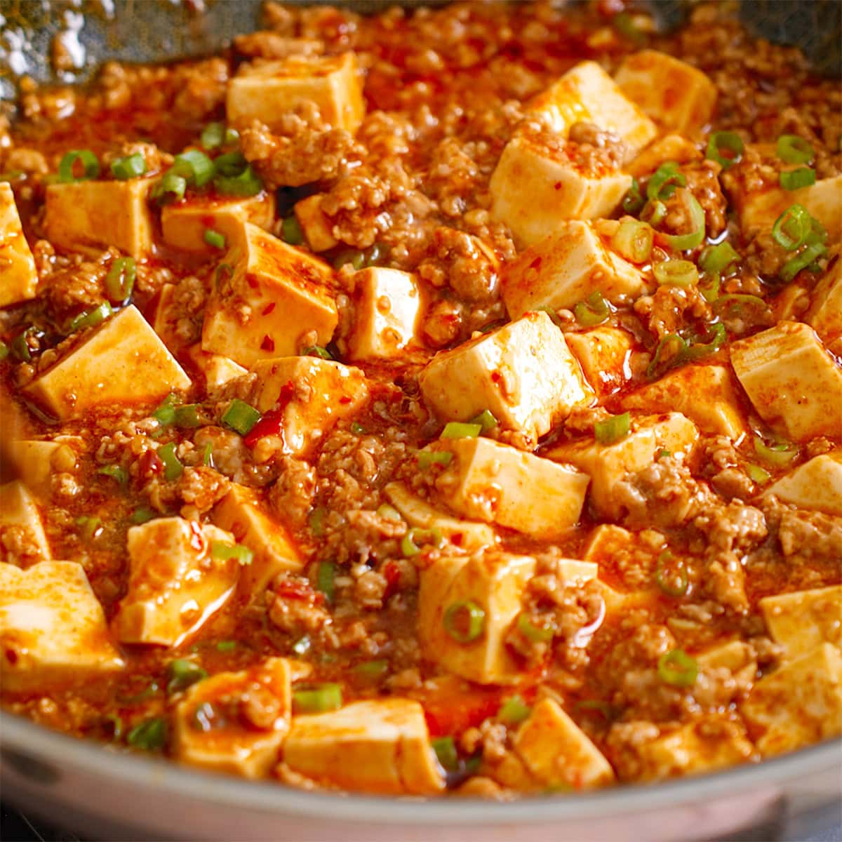 Mapo tofu fully mixed together in a wok.