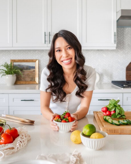 megan leaning over counter with strawberries