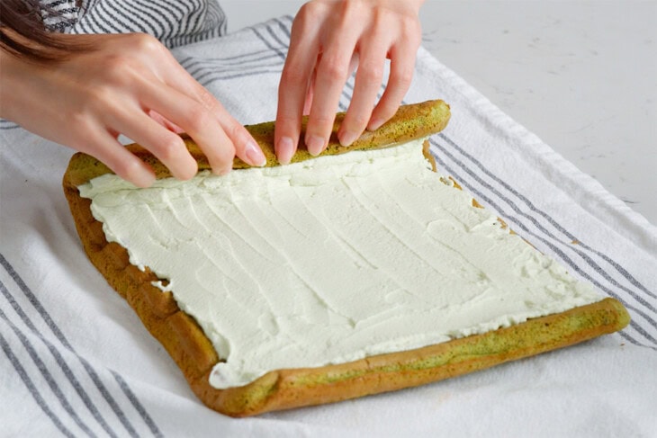 Rolling up a matcha cake roll.