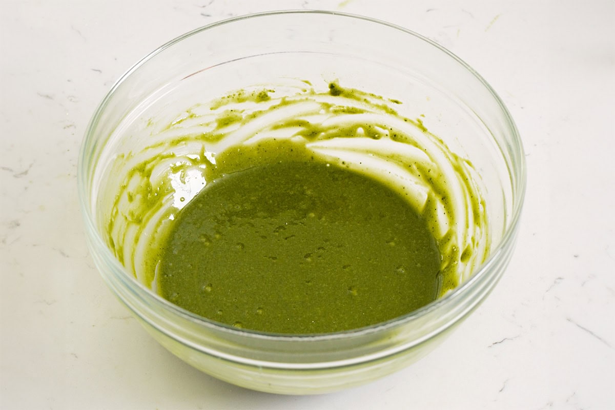 Wet ingredients mixed with dry matcha ingredients in a bowl.