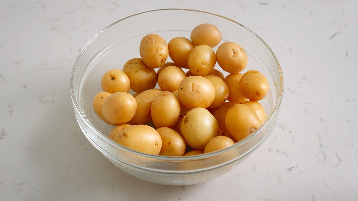 A bowl of baby potatoes that has been boiled.