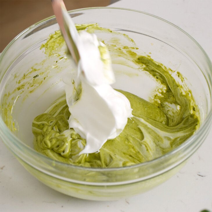 Folding meringue into the cake batter.