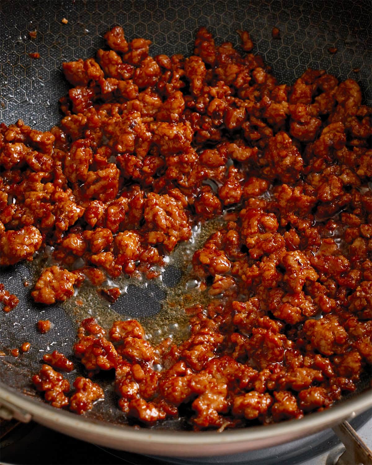 Ground pork and sauce being cooked in a wok.