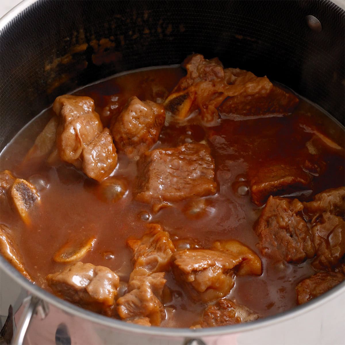 Short ribs braising in a large pot.