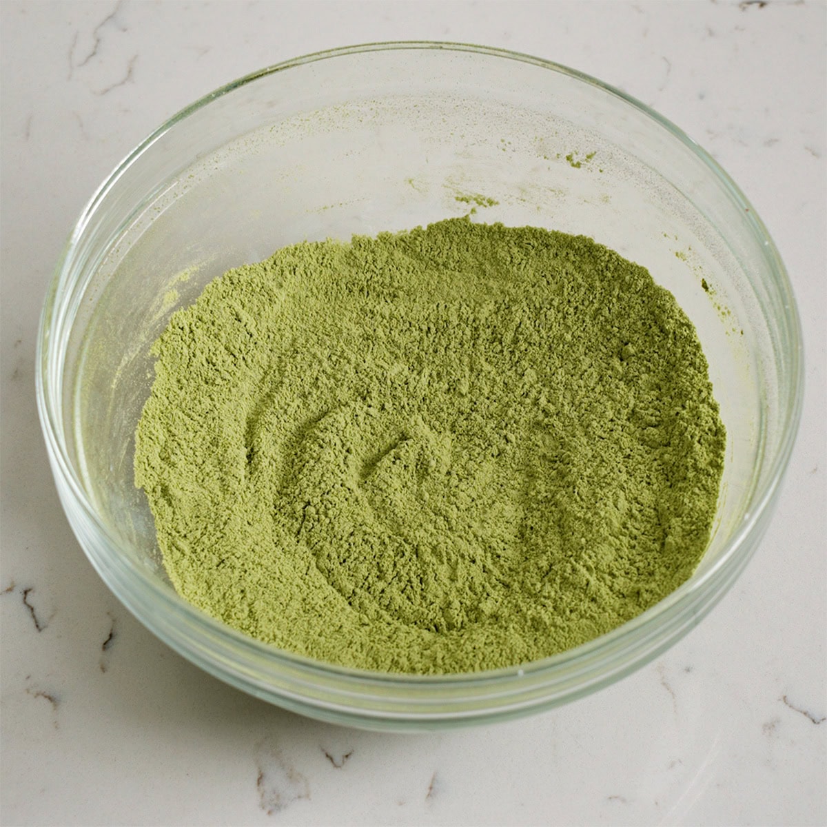 Matcha and dry ingredients sifted into a bowl.