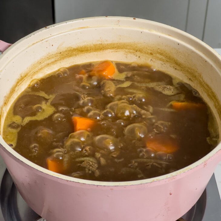 The broth thickening with the curry roux mixed in.