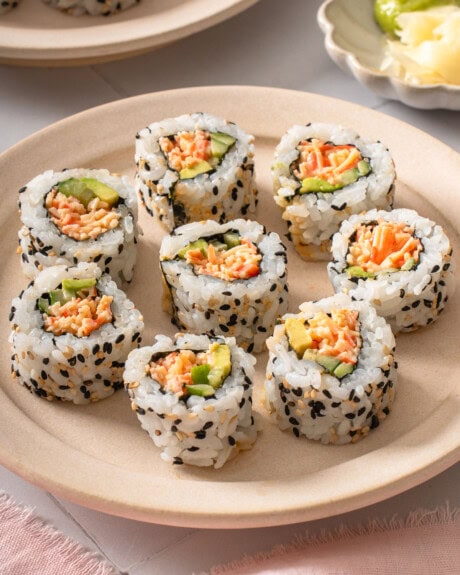 A plate of kani sushi surrounded by table settings.