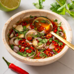 A bowl of prik nam pla with a spoon in it.
