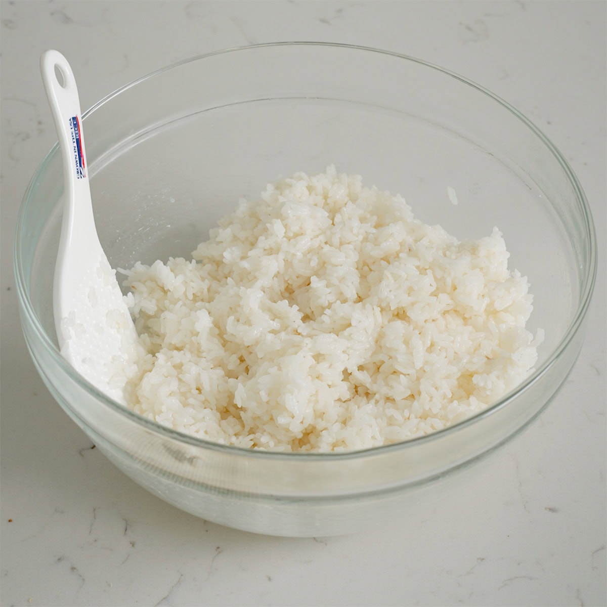 Sushi rice seasoned in a glass bowl.