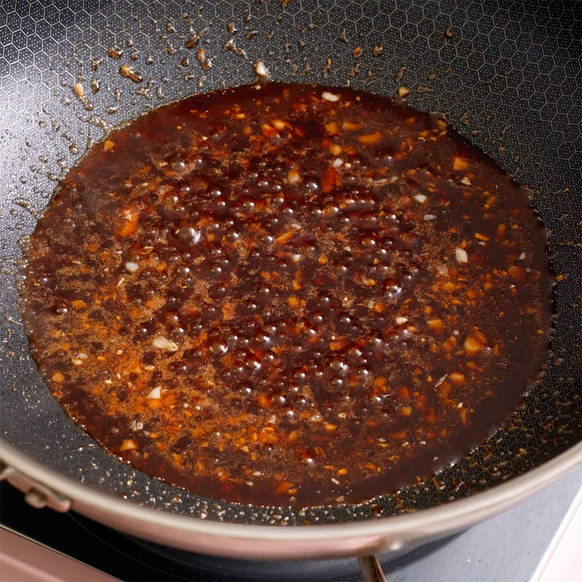 The sesame sauce thickening in a large wok.