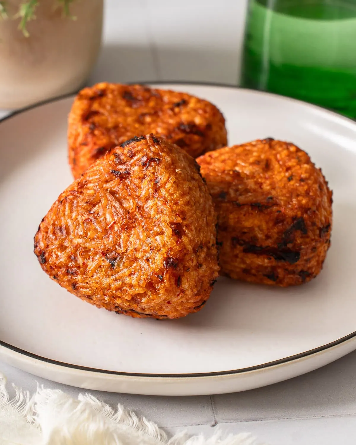 A few kimchi rice balls served on a plate.