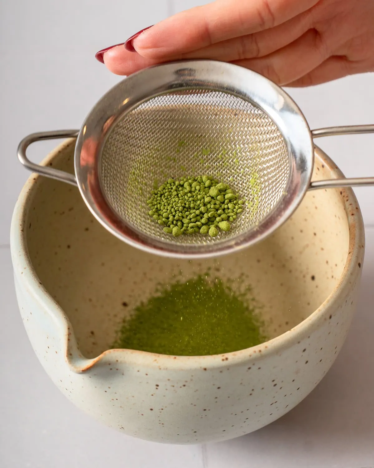 Sifting matcha into a bowl.