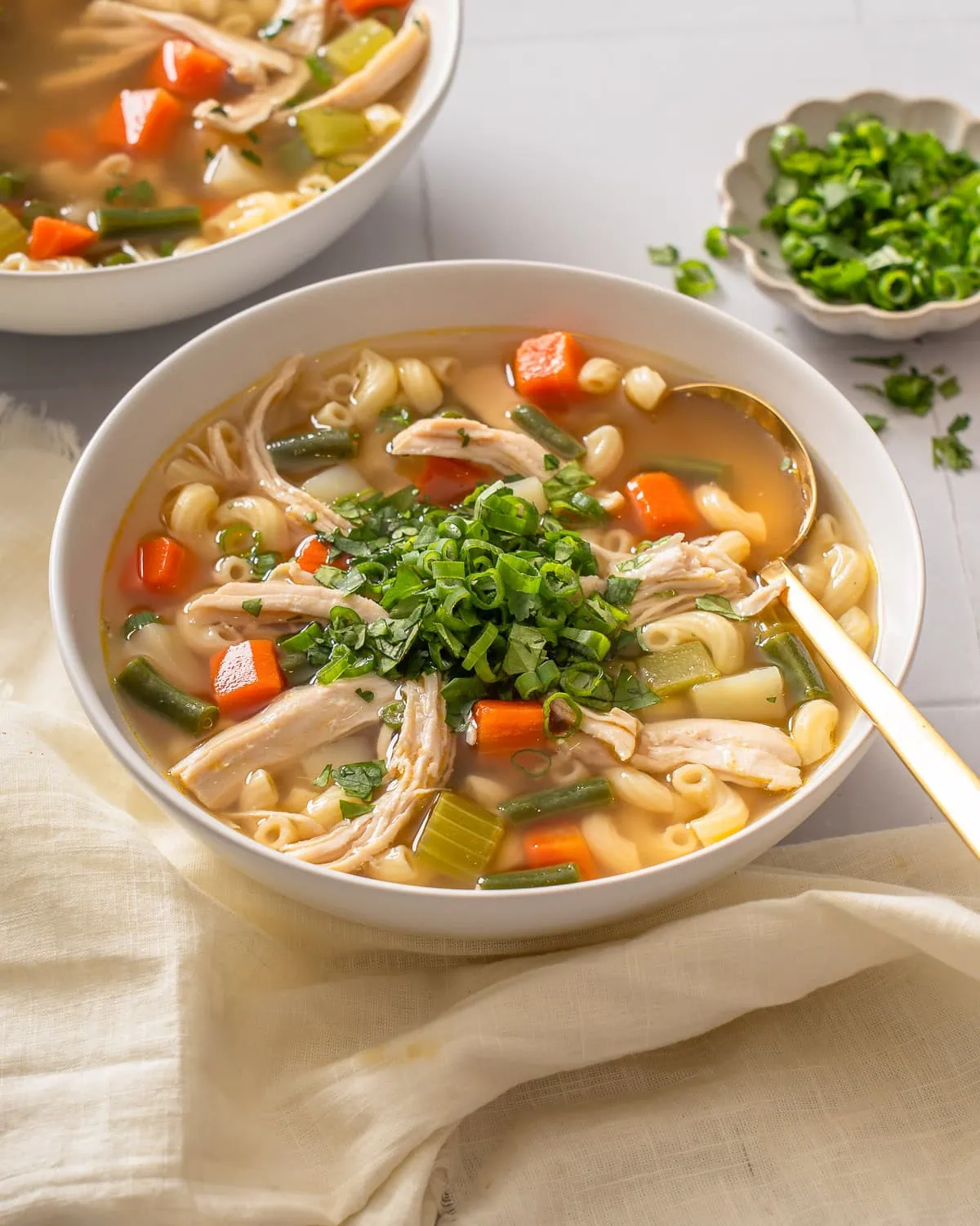 A bowl of vietnamese chicken noodle soup with a spoon in it.