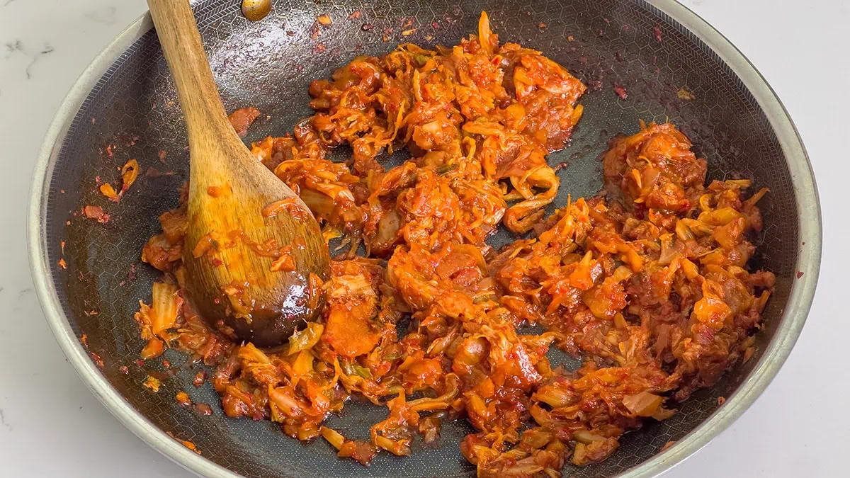 Seasoned cooked down kimchi in a large skillet.